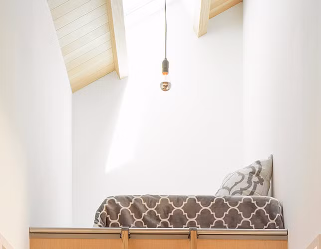 Một cái nhìn gần hơn cho phòng ngủ nhỏ, ga giường có hoạ tiết hiện đại. Nơi ngủ này cũng gọn gàng và hạn chế tối đa đồ nội thất vì không có nhiều diện tích trên đó.