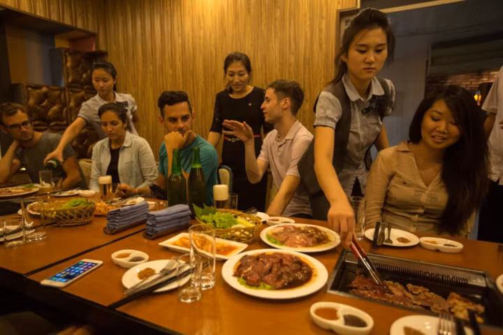 Nhóm du khách Mỹ và Pháp thưởng thức món ăn tại một nhà hàng ở Bình Nhưỡng.