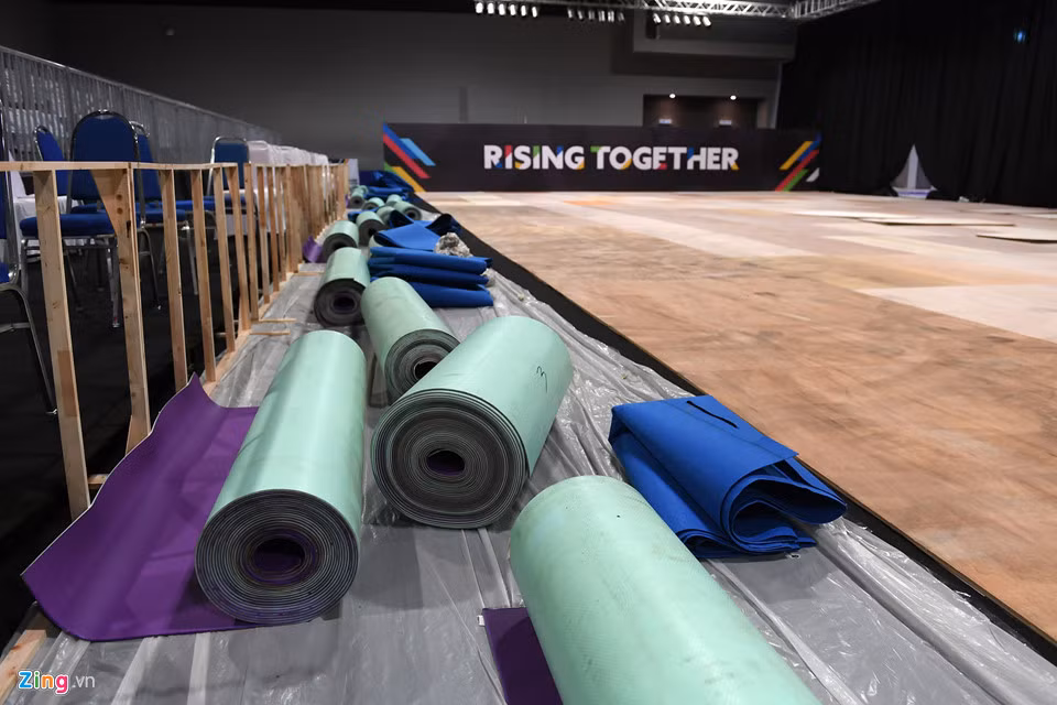 Trên cùng là các tấm thảm nền thi đấu chuyên dụng của từng môn. Cách trải thảm nền thi đấu này nhằm giảm chấn thương cho các VĐV mỗi khi bật nhảy hoặc tiếp đất.