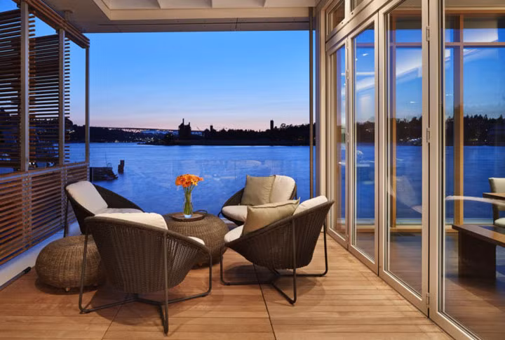 Sân hiên phía giáp với nhà bếp có khu vực tiếp khách nhỏ. Một bức tường thủy tinh dọc căn nhà cho phép ánh sáng tự nhiên nhiều hơn nhưng vẫn giữ được sự riêng tư.