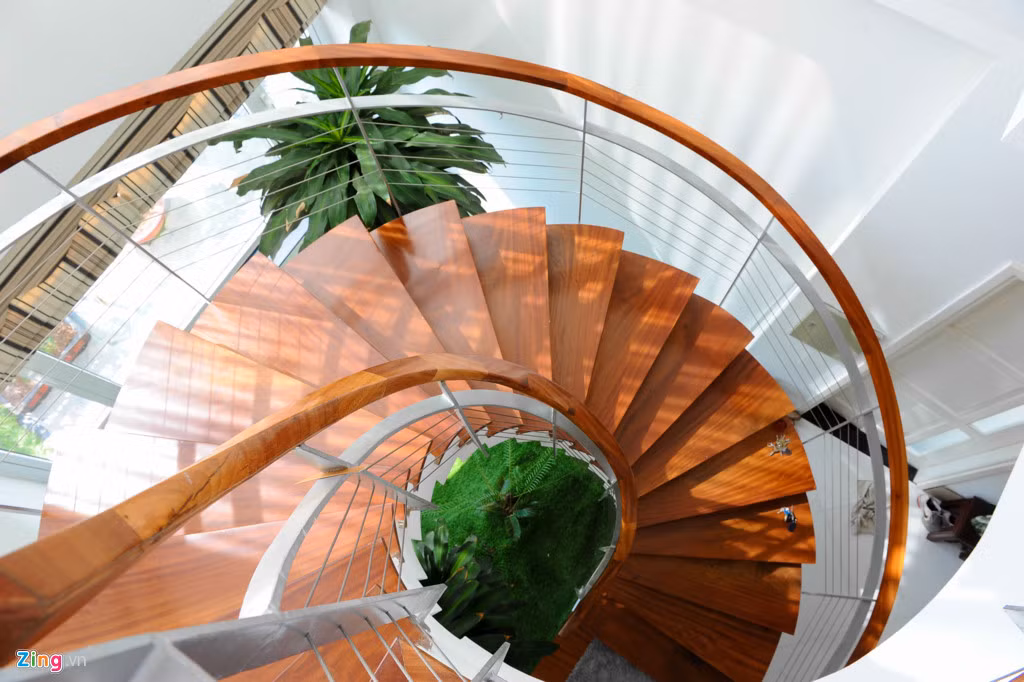 Cầu thang nối các phòng được thiết kế hình xoắn ốc lát gỗ. Chủ nhà ưu ái dùng một tấm cửa sổ lớn xuyên suốt từ thấp lên cao chạy theo cầu thang giúp lấy ánh sáng và cảm giác gần gũi với thiên nhiên khi di chuyển.