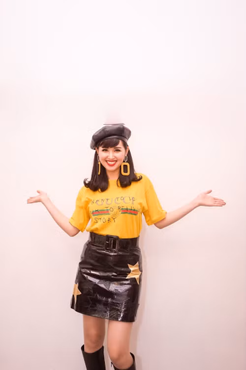 Hot girl Tâm Tít mix áo thun hàng hiệu với chân váy da trẻ trung đến dự một sự kiện. 'Gái hai con' còn đeo hoa tai, đội mũ cá tính để hoàn thiện phong cách sành điệu.