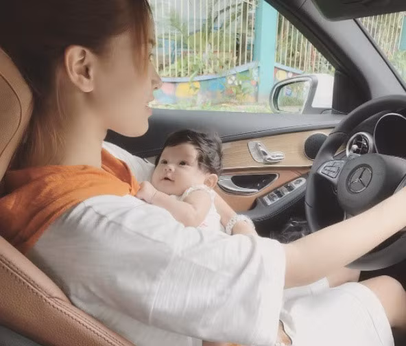 Hình ảnh Hải Băng vừa ôm con vừa cầm lái gây tranh cãi. Ảnh: Instagram.