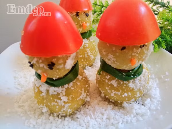 Bước 6: Nặn bột thành hai loại viên tròn to và nhỏ rồi cho vào nồi hấp chín. Bước 7: Lăn viên bánh đã hấp qua đĩa vụn dừa Bước 8: Tạo hình người: đặt viên bánh to xuống dưới làm mình, lấy que xiên xiên vào giữa rồi xiên viên bánh bé lên trên làm đầu. Dùng hạt vừng đen làm mắt, dùng một mẩu cà rốt làm mũi, lấy hành đã trần làm khăn quàng cổ, lấy miếng cà chua làm mũ.