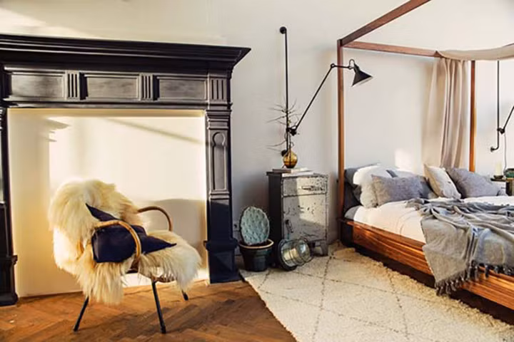 Một chiếc ghế thoải mái và khung hình cổ điển được thêm vào bên cạnh giường.