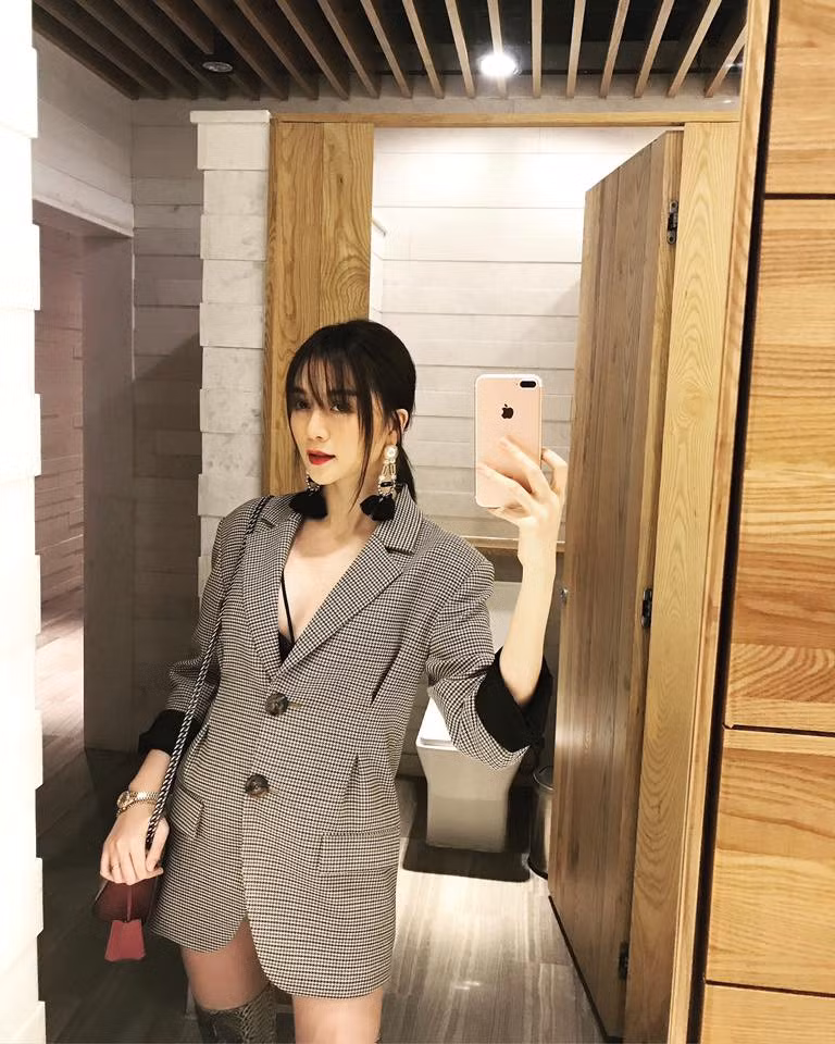 Nữ ca sĩ Thiều Bảo Trang yêu thích chiếc áo blazer kẻ ô sắc xám. Cô mang đến vẻ gợi cảm khi mix cùng boots cao cổ và hoa tai to bản sành điệu.