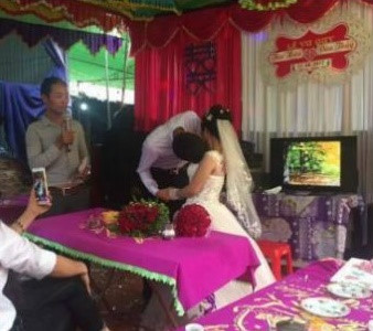 Chú rể gặp khó khăn khi hôn cô dâu trong đám cưới. Ảnh: Hoàng Sơn.