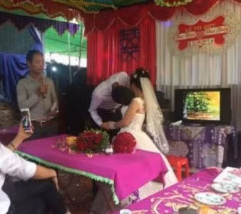 Chú rể gặp khó khăn khi hôn cô dâu trong đám cưới. Ảnh: Hoàng Sơn.