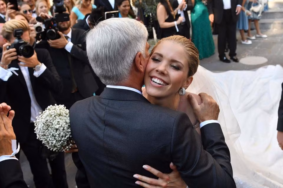 Ông Paul Swarovski - cha Victoria - là người dắt tay con gái băng qua lễ đường nhà thờ San Giusto đến nơi chú rể đang chờ đợi để trao lời hẹn ước. Trong ảnh, Victoria ôm một vị khách sau màn thề nguyện với bạn đời.