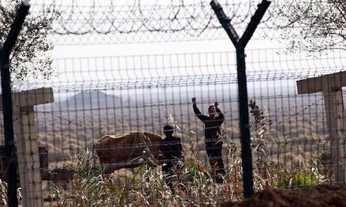 Người dân Triều Tiên đứng bên bờ thị trấn Sinuiju nằm đối diện với TP biên giới Đan Đông của Trung Quốc. Ảnh: REUTERS