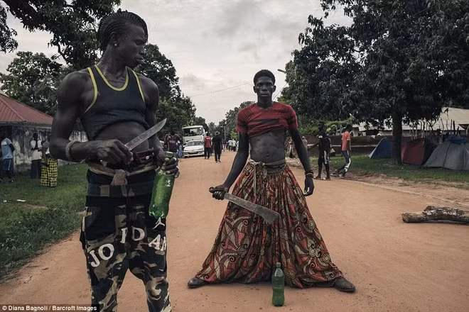 Một thanh niên cầm dao, chuẩn bị bước vào lễ trưởng thành.