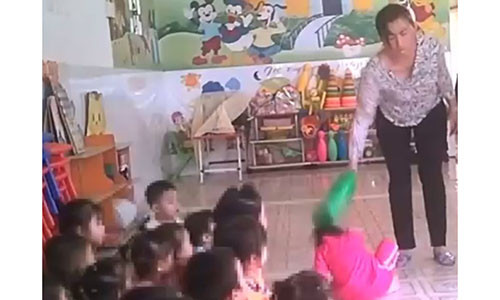 Bảo mẫu đánh liên tiếp vào đầu đứa trẻ. Ảnh cắt từ clip Tuổi Trẻ.