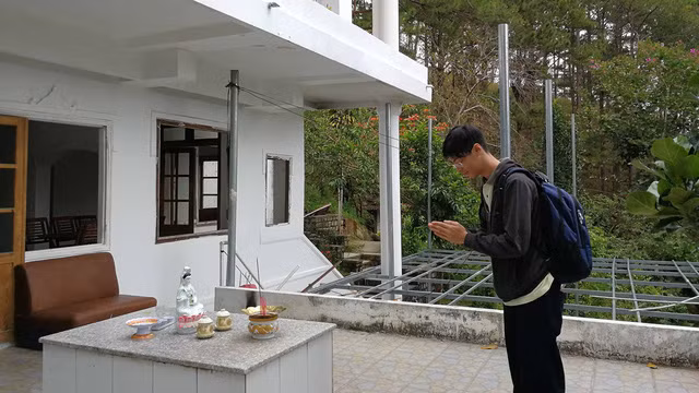 Một du khách thắp nhang tại ngôi nhà ma với thái độ kính cẩn - Ảnh: MAI VINH