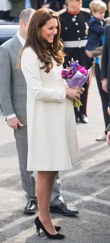 Thời điểm đang mang bầu, Kate Middleton vẫn tự tin diện áo khoác dáng dài gam trắng kết hợp cùng giày cao gót khi đến thăm bộ Tu viện Downton ở Ealing Studios, London, Anh.