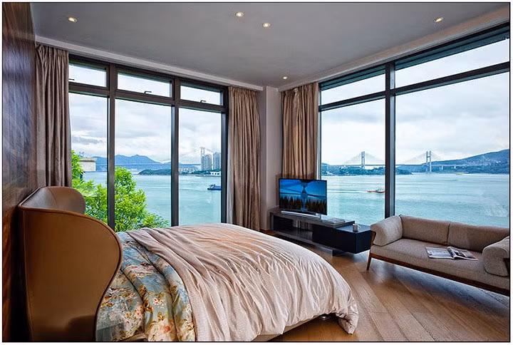 Thiết kế phòng ngủ hướng ra sông, tận dụng hết mức khoảng không gian giá trị nhờ sử dụng tường kính cao sát trần.