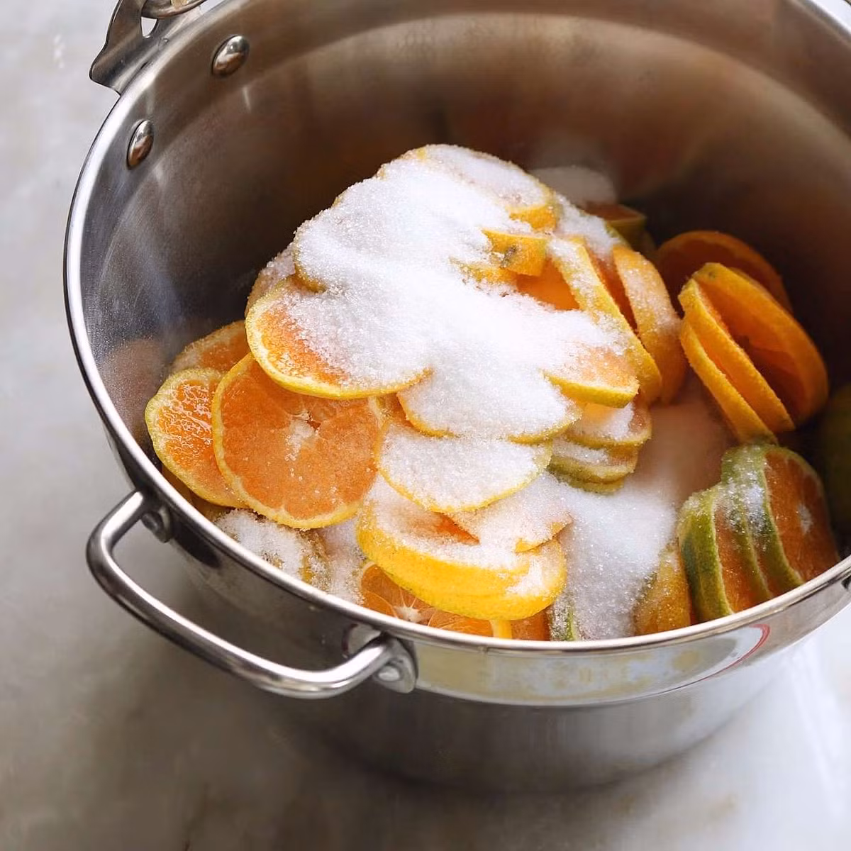 Lấy hết hạt quất ra rồi xếp vào một nồi lớn, cho đường vào rồi để ở nhiệt độ phòng khoảng 1 ngày hoặc đến khi đường tan hết ra.