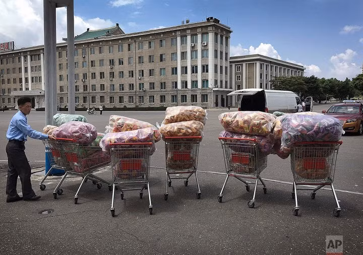 Người đàn ông đứng đợi ở bãi đỗ xe bên ngoài cửa hàng Potonggang, Bình Nhưỡng. (Ảnh: AP)