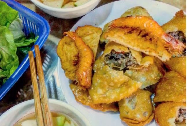 Bánh gối: Bánh gối là món ăn quen thuộc của các tín đồ ăn vặt. Nhân bánh đầy đặn được gói trong lớp vỏ chiên vàng ươm đẹp mắt. Món này chấm với nước mắm chua ngọt, chút cay cay kèm với nộm đu đủ, rau sống cho bớt ngấy. Ảnh: Trà My.