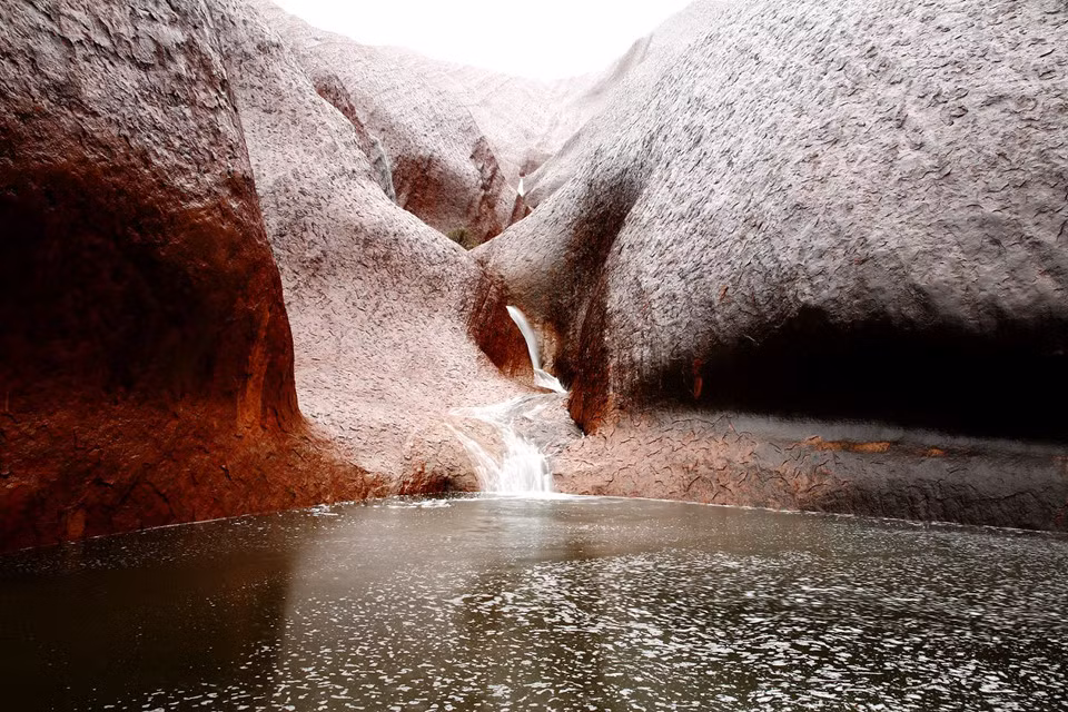 Các dòng thác đổ xuống một hồ nước dưới chân Uluru. Bên cạnh lý do bảo tồn, việc cấm hoạt động leo núi tại Uluru cũng xuất phát từ vấn đề an toàn cho du khách. Từ thập niên 50 thế kỷ trước, ít nhất 36 người được báo cáo tử vong do leo lên núi Uluru. Trong giai đoạn 2002-2009, 72 du khách được giải cứu và cần tới điều trị y tế do leo núi. Ảnh: Getty.