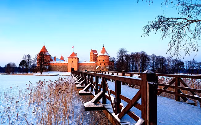 Lâu đài Trakai, Lithuania: Nằm cách mười bảy dặm về phía tây của Vilnius, lâu đài Traikai càng trở nên lộng lẫy hơn vào những tháng mùa đông, khi hồ nước xung quanh bị đóng băng và các chóp nhọn lợp ngói đỏ của tòa lâu đài bị tuyết phủ lốn đốm càng trở nên nổi bật trong sắc trắng bao phủ khắp mọi nơi.