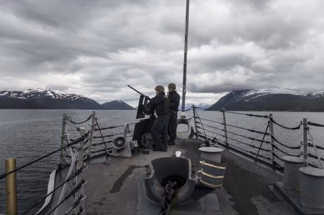 Các binh sĩ quân đội Mỹ giữ một khẩu súng máy .50-caliber trên tàu khu trục tên lửa dẫn đường USS Ross, khi chiến hạm đang di chuyển trên biển Na Uy.