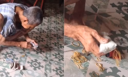 Hình ảnh cụ bà ngồi gỡ từng lớp giấy bọc cẩn thận cuộn tiền lẻ. Ảnh cắt từ clip