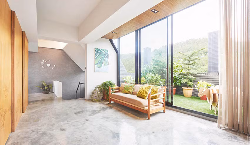 Toàn bộ phần tường bên ngoài được thay thế bằng cửa trượt lớn với chất liệu kính và khung kim loại. Ngồi trong phòng khách có thể nhìn thẳng ra ban công trước mắt với thảm cỏ xanh và rất nhiều cây trang trí vô cùng tươi mát. Thiết kế này giúp phòng khách trông vô cùng rộng rãi và thoáng mát.