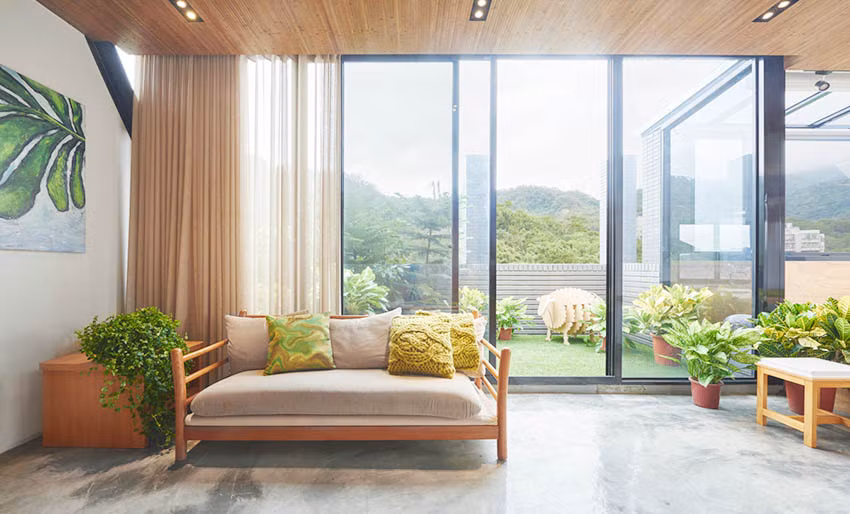 Phòng khách của căn hộ này không sử dụng cầu kỳ nội thất, chỉ dùng một chiếc ghế sofa dài với chất liệu gỗ, thiết kế đơn giản nhưng tinh tế. Tường gỗ được lắp đặt ngay trong phòng khách thay thế cho tường gạch và bê tông thông thường, giúp căn phòng tạo cảm giác thư thái và dễ chịu hơn. Điểm đặc biệt là chiếc tường gỗ này cũng chính là một chiếc cửa trượt vừa có tác dụng ngăn cách phòng khách với không gian bên trong, vừa che giấu một chiếc tủ để đồ cực lớn chính là không gian lưu trữ của ngôi nhà.