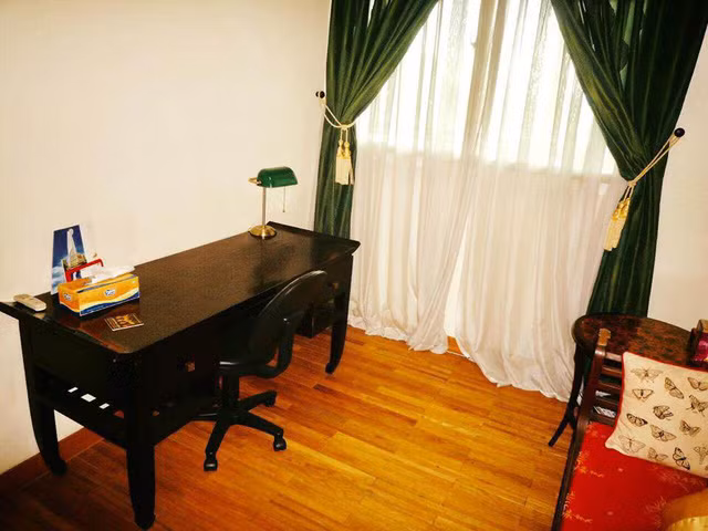 Một phòng ngủ khác có bàn làm việc đặt gần cửa sổ.