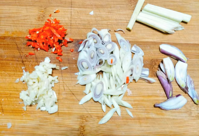 Hướng dẫn cách làm món khô gà lá chanh: - Bước 1: Sả rửa sạch rồi đập dập, xắt khúc 1 cây, cây sả còn lại đem thái miếng vát chéo, tỏi+ ớt băm nhỏ, hành khô thái lát. Thịt ức gà+ lá chanh rửa sạch để ráo nước.