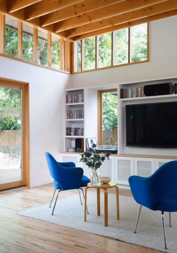 Những song gỗ kết nối với nhau bằng lớp kính cường lực trong suốt, vừa giữ an toàn cho mọi người sống trong nhà vừa mang ánh sáng đến mọi góc nhỏ. Không gian tiếp khách được ốp sàn gỗ màu sáng, kết hợp với tường trắng mang lại vẻ đẹp tươi tắn, thanh lịch cho căn phòng.