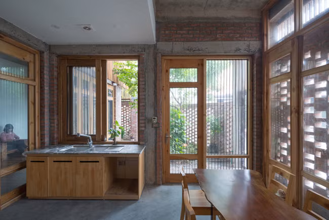 Ngay trong hệ thống lam gỗ, gia chủ cho lắp thêm một lớp kính để đảm bảo sự an toàn và riêng tư cho gia đình. Nhờ thế, ngôi nhà vừa đủ sáng, đủ gió, thân thiện với thiên nhiên và vẫn đủ cả sự kín đáo.