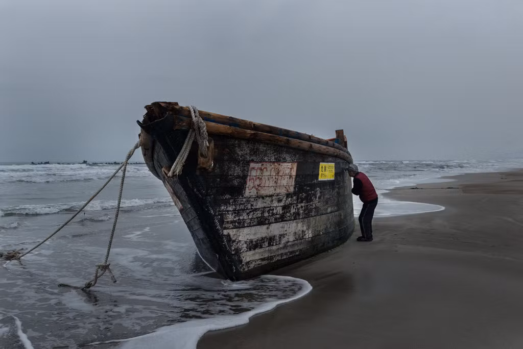Con tàu trôi dạt vào bờ biển thành phố Oga hôm 27/11. Ảnh: New York Times.