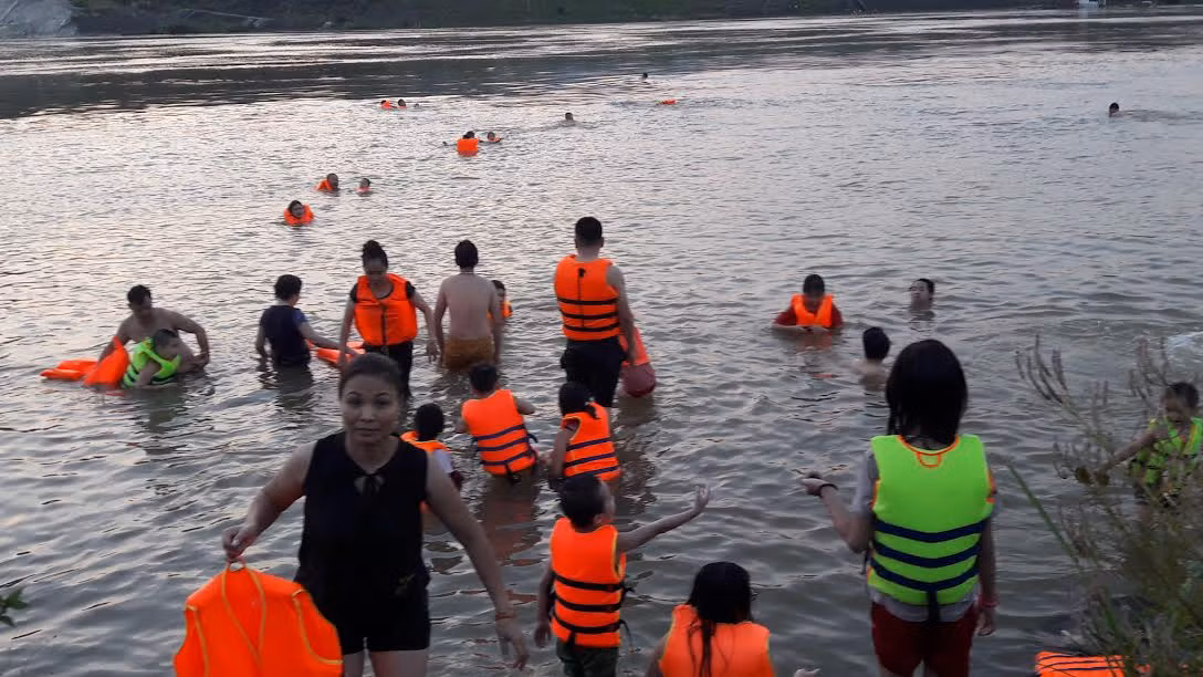 Bãi cát ở phường Phương Lâm phía dưới chân đập thủy điện Hòa Bình đang trở thành bãi tắm lý tưởng của người dân trong những ngày hè nắng nóng kỷ lục như thế này.