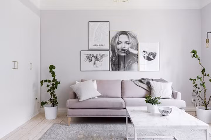 Phòng khách sử dụng các tông màu sáng với những khung ảnh trang trí cá tính.