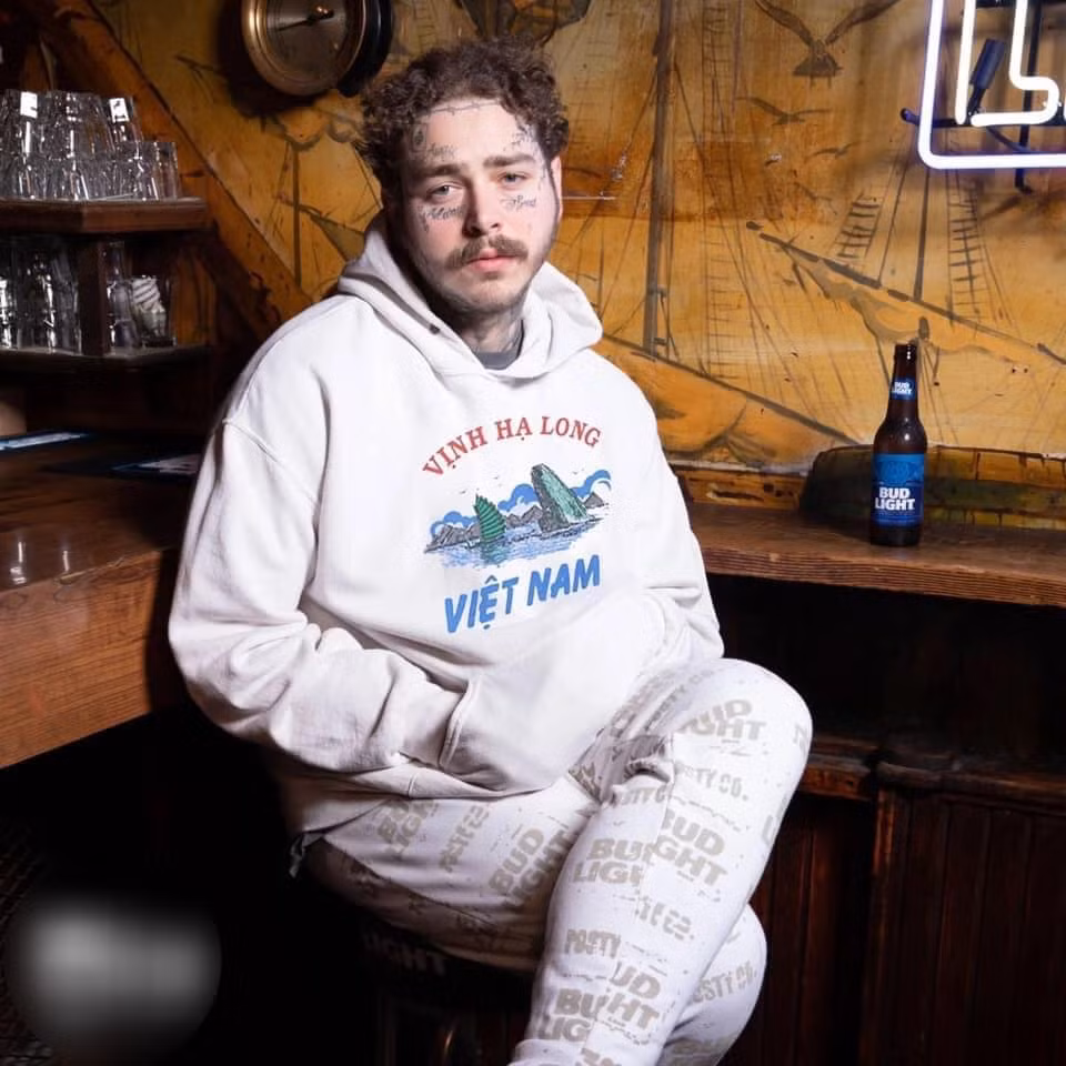 Post Malone thậm chí còn phong cách hơn trong thiết kế hoodie trắng nhưng điểm nhấn chính là chiếc logo hòn Trống Mái của Vịnh Hạ Long.