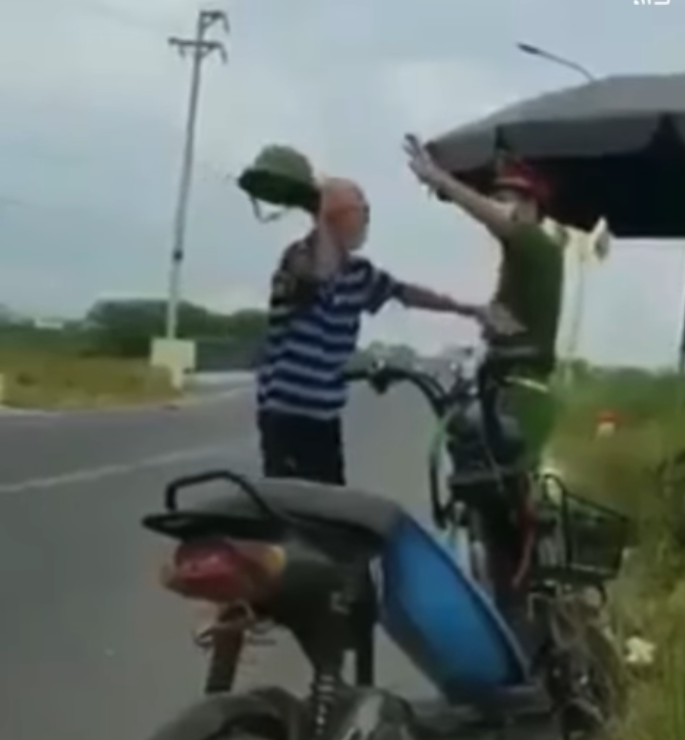 Theo clip ghi lại, cụ ông đi xe đạp điện bị chốt kiểm dịch giữ lại do vi phạm Chỉ thị giãn cách. Thay vì chấp hành thì cụ lại cầm mũ cối, liên tục dơ tay đánh về phía công an, vừa buông lời chửi tục tĩu tại chốt kiểm dịch.