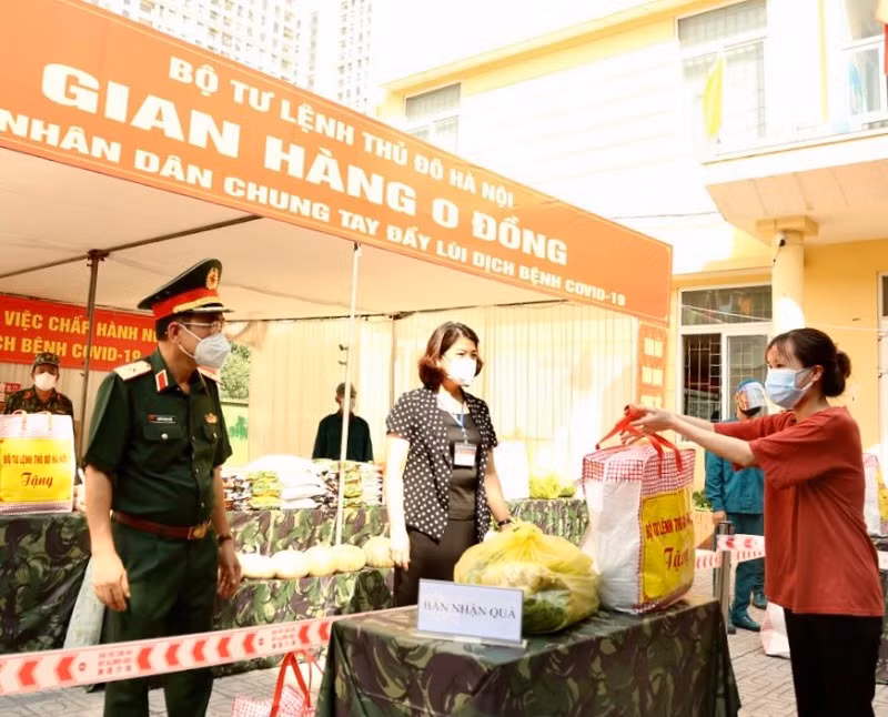 Thiếu tướng Nguyễn Trọng Triển - Chính ủy Bộ Tư lệnh Thủ đô Hà Nội trao quà cho người dân tại phường Mỹ Đình 1 (quận Nam Từ Liêm, TP Hà Nội).