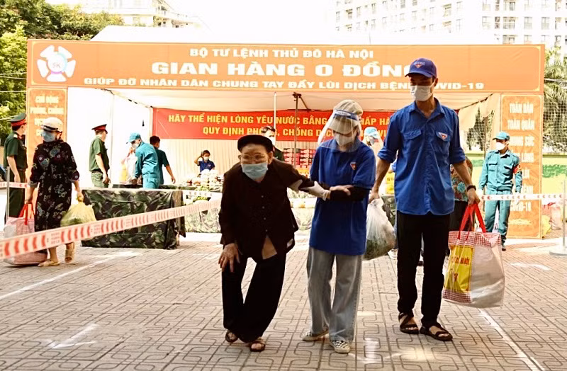 Các tình nguyện viên phường Mỹ Đình 1 giúp người khó khăn, người già mang những nhu yếu phẩm được tặng từ Gian hàng 0 đồng về tới tận nhà.