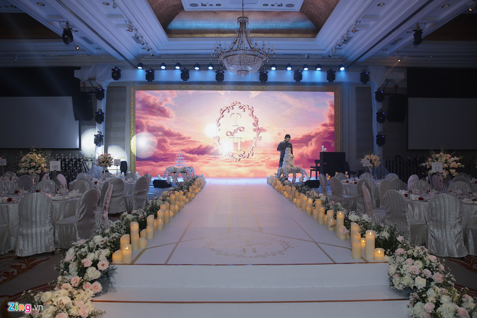 Đường dẫn lên sân khấu khá lãng mạn với hoa tươi và nến được trang trí ở hai bên. Trên sân khấu có sẵn đàn piano để phục vụ cho các tiết mục văn nghệ trong tiệc cưới. Trước giờ diễn ra, nhân viên khách sạn kiểm ra lại các chi tiết lần cuối.