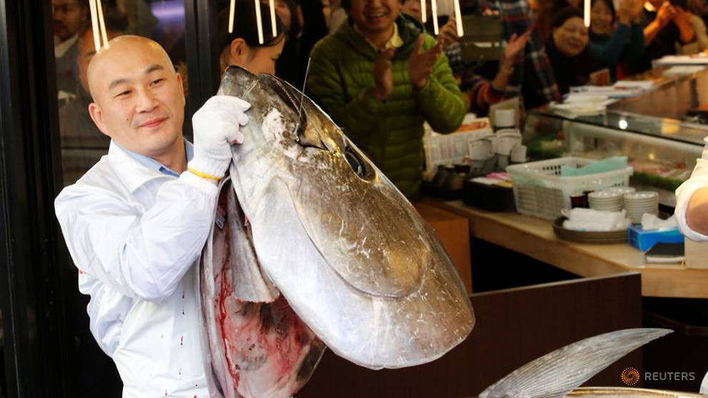 Nhân viên nhà hàng của ông Kimura giữ đầu con cá ngừ vừa bị xẻ thịt.