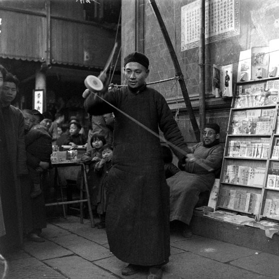 Rất đông người theo dõi màn biểu diễn trò chơi dân gian của một nghệ nhân.