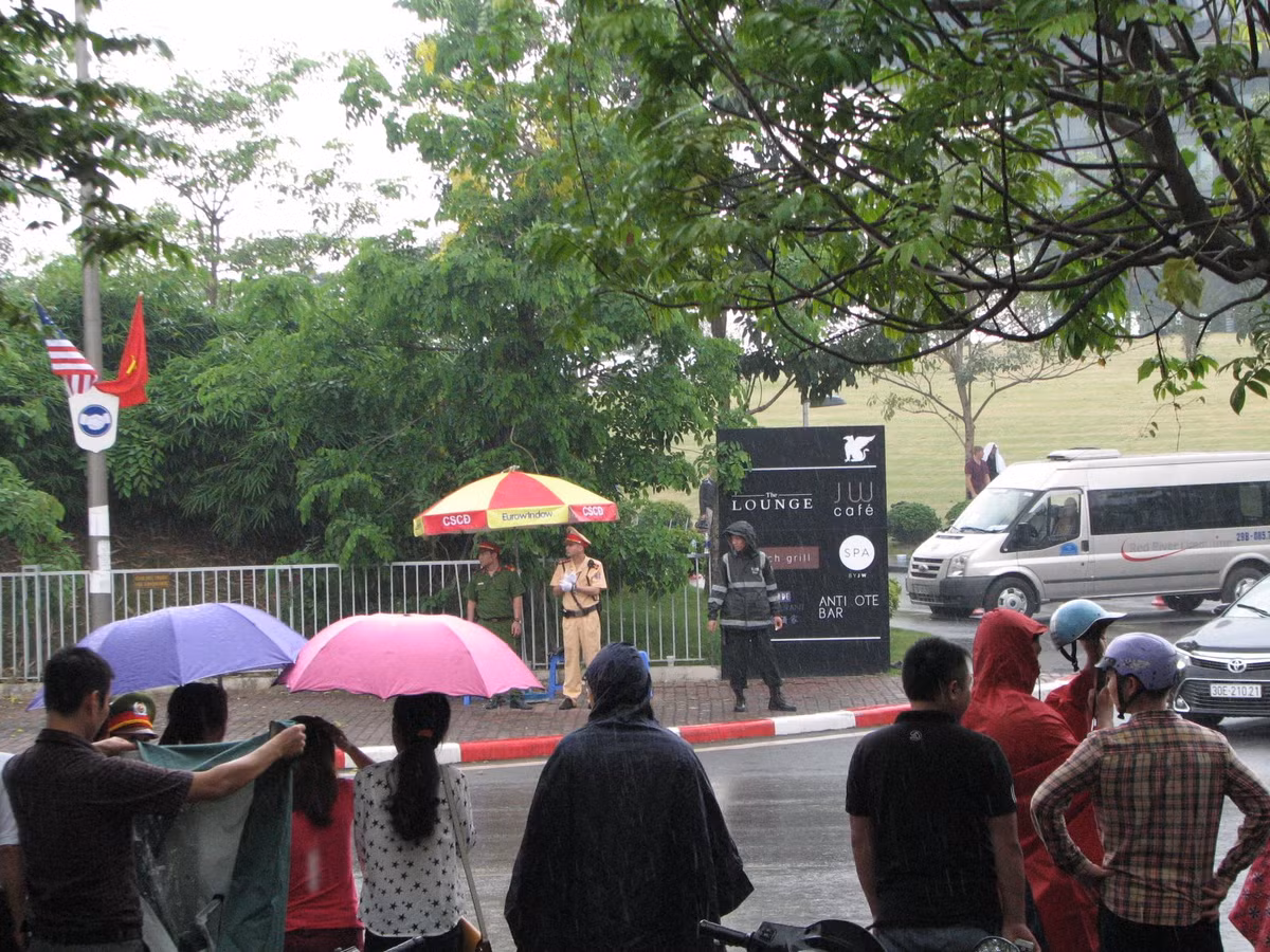 Khoảng 10h45, trời bất ngờ đổ mưa lớn nhưng nhiều người dân vẫn quyết bám trụ, mong được nhìn thấy người đàn ông quyền lực.