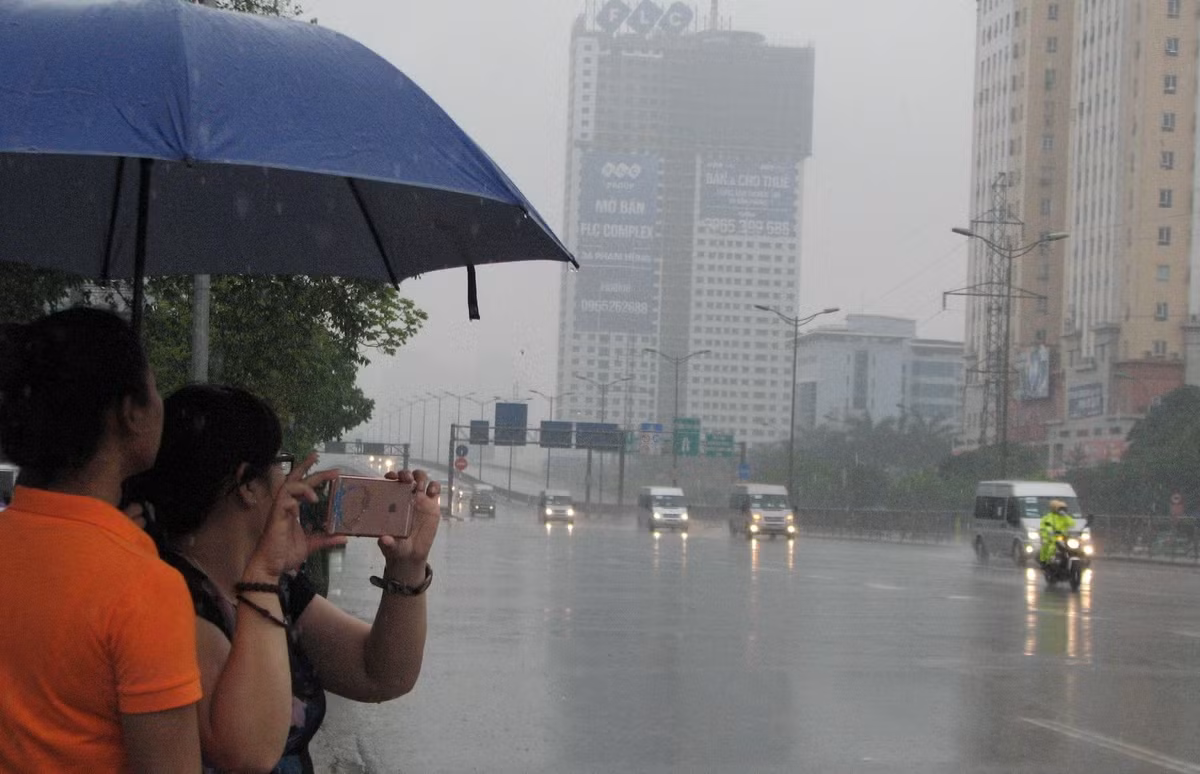 Người dân đội mưa đứng bên đường hào hứng theo dõi. Sau khi rời Hà Nội, Tổng thống Obama sẽ tới thăm và làm việc tại TP HCM trong chiều nay.