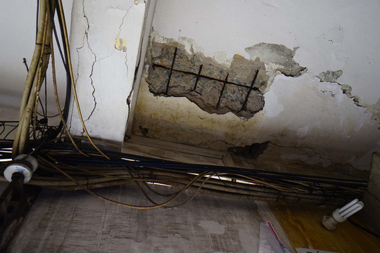 Khu vực tầng 1 những mảng vữa bị bong tróc, trần nhà bị bong nhìn rõ từng lõi thép bên trong. Ảnh: NLĐ.