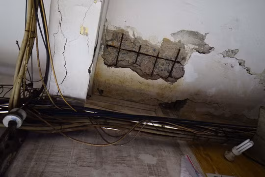 Khu vực tầng 1 những mảng vữa bị bong tróc, trần nhà bị bong nhìn rõ từng lõi thép bên trong. Ảnh: NLĐ.