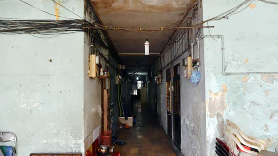 Phía trong chung cư nhiều vị trí tường đã bị bong tróc, rỉ nước, mái tôn thủng lỗ. Các bậc cầu thang bị bể phần xi măng, căn hộ xuống cấp, kính cửa sổ nhiều tấm bị vỡ được tháo rời khỏi khung... Ảnh: TTO.