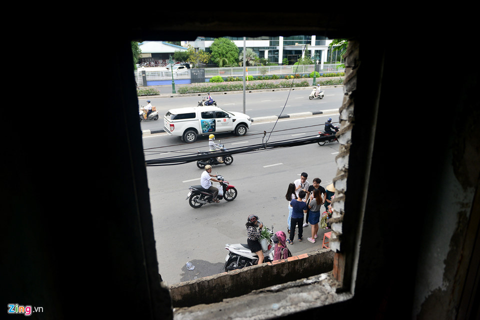 Mặt trước chung cư khá nhếch nhác với dây điện chằng chịt, các hộ cơi nới ban công... Mái chung cư bị thủng, ánh sáng có thể lọt vào, tấm la-phông bằng gỗ rách nát khiến khu vực trần cầu thang các mảng tường mọc rêu, ẩm mốc do thấm nước.... Ảnh: Zing.