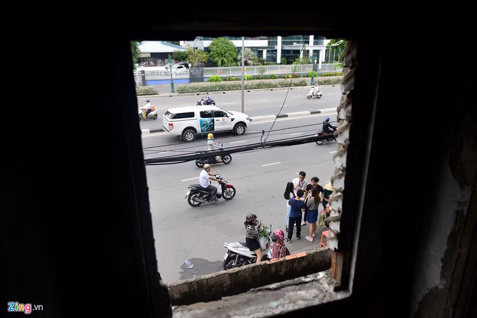 Mặt trước chung cư khá nhếch nhác với dây điện chằng chịt, các hộ cơi nới ban công... Mái chung cư bị thủng, ánh sáng có thể lọt vào, tấm la-phông bằng gỗ rách nát khiến khu vực trần cầu thang các mảng tường mọc rêu, ẩm mốc do thấm nước.... Ảnh: Zing.