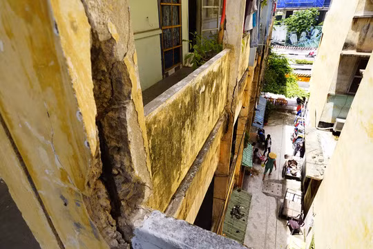 Chung cư gồm ba lô A, B, C nối thành hình chữ U. Phần tường cũ nát, rêu bám thành mảng loang lổ, dây điện chằng chịt khắp nơi. Cột nhà nứt, trụ sắt đỡ thì bị hoen gỉ. Ảnh: NLĐ.